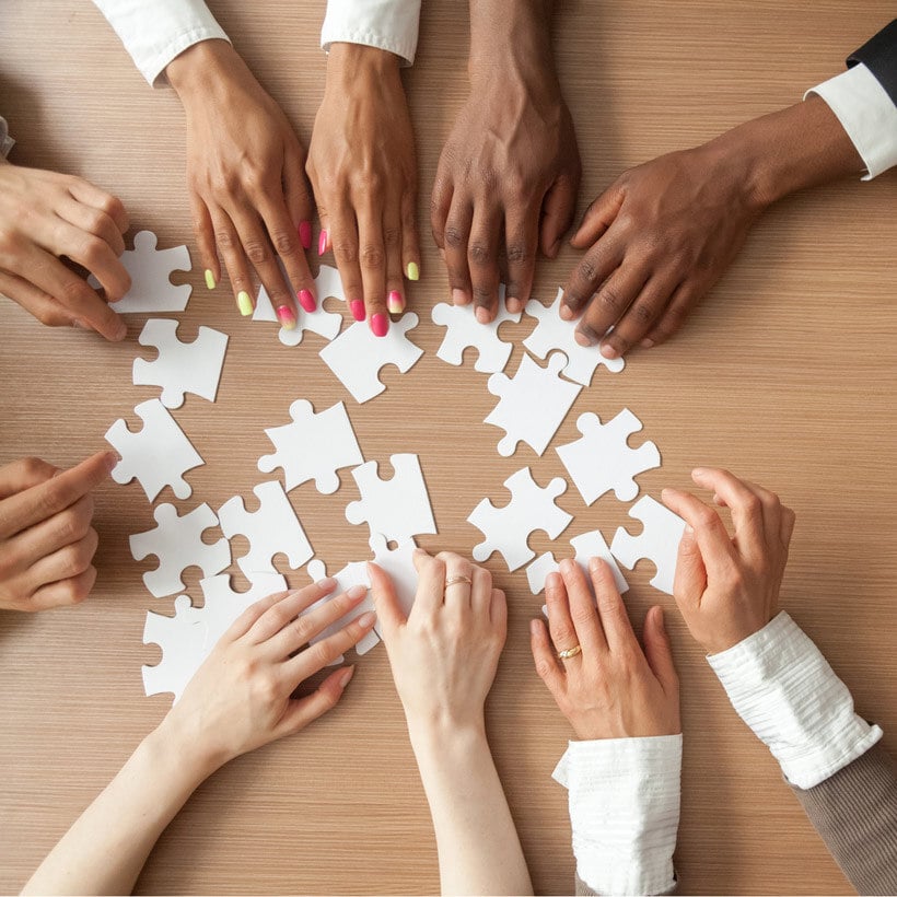 diverse hands touching puzzle